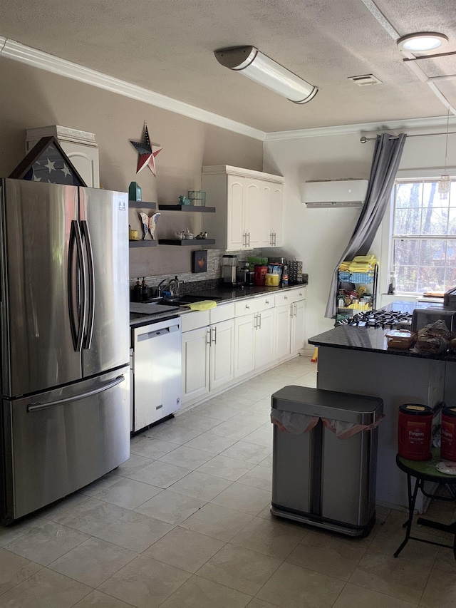 kitchen featuring stainless steel appliances, a sink, white cabinets, dark countertops, and crown molding