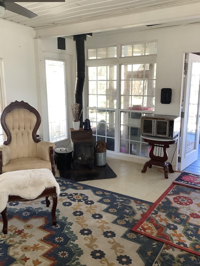 living area with tile patterned flooring and a wood stove