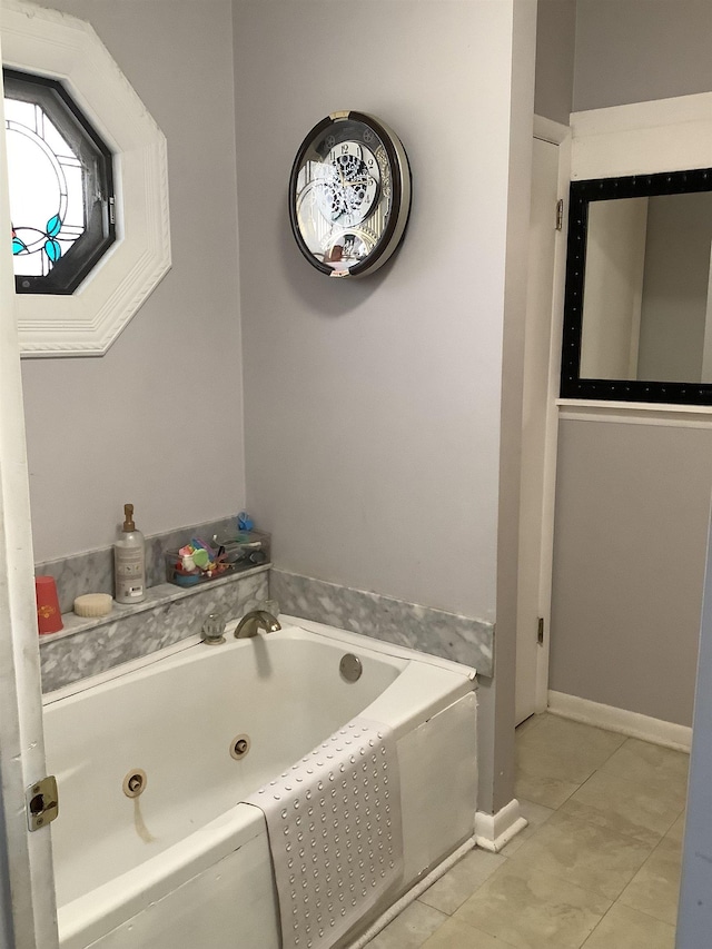 full bath with a tub with jets, tile patterned flooring, and baseboards