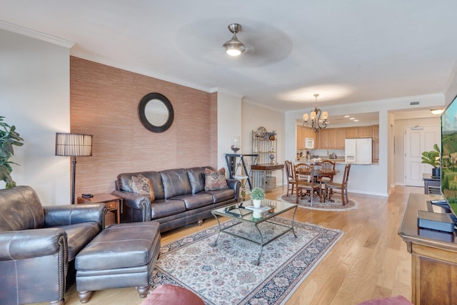 121 N Monroe St Unit 1103, Tallahassee, FL 32301 - living room with a chandelier, light wood-type flooring, an accent wall, crown molding, and baseboards