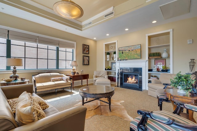 121 N Monroe St Unit 1103, Tallahassee, FL 32301 - carpeted living area with built in shelves, a tile fireplace, crown molding, a raised ceiling, and recessed lighting