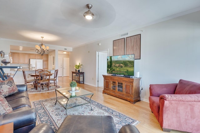121 N Monroe St Unit 1103, Tallahassee, FL 32301 - living room featuring a chandelier, ornamental molding, light wood-type flooring, and baseboards
