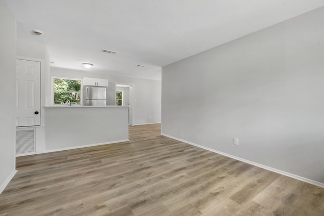 319 Meadowbrook Ln, Tallahassee, FL 32304 - unfurnished living room featuring baseboards and light wood-type flooring