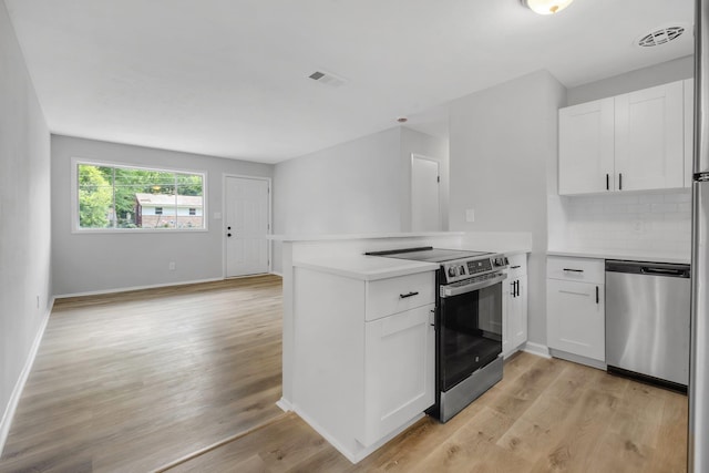 319 Meadowbrook Ln, Tallahassee, FL 32304 - kitchen with appliances with stainless steel finishes, a peninsula, light wood-type flooring, white cabinets, and light countertops