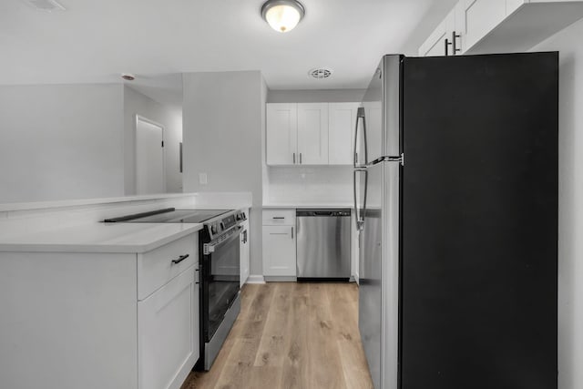 319 Meadowbrook Ln, Tallahassee, FL 32304 - kitchen with appliances with stainless steel finishes, white cabinetry, a peninsula, light wood-type flooring, and light countertops