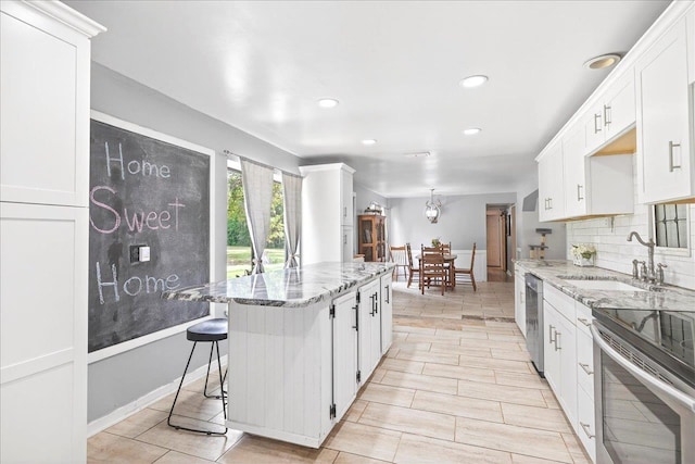 147 Hawk Ridge Dr, Havana, FL 32333 - kitchen featuring light stone counters, stainless steel appliances, white cabinetry, a kitchen island, and recessed lighting