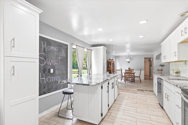 147 Hawk Ridge Dr, Havana, FL 32333 - kitchen with light stone counters, dishwasher, white cabinets, a kitchen island, and recessed lighting