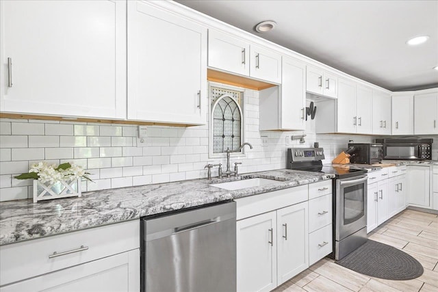 147 Hawk Ridge Dr, Havana, FL 32333 - kitchen with stainless steel appliances, white cabinets, tasteful backsplash, light stone counters, and recessed lighting