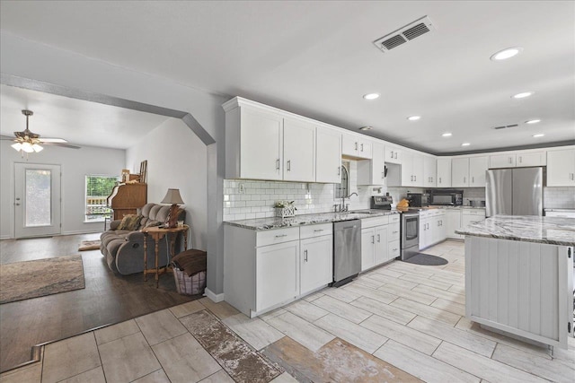 147 Hawk Ridge Dr, Havana, FL 32333 - kitchen featuring appliances with stainless steel finishes, wood tiled floors, decorative backsplash, light stone countertops, and recessed lighting