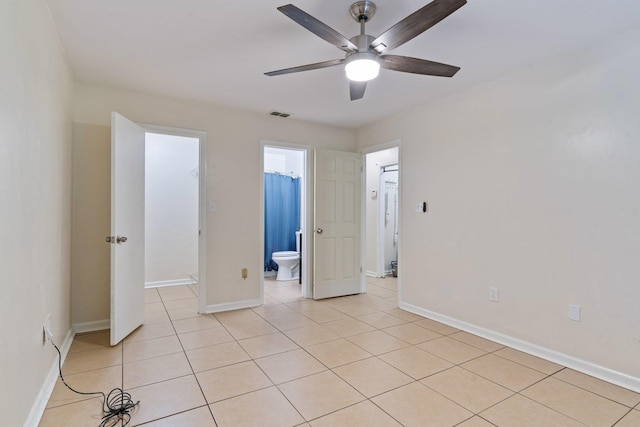 tiled empty room featuring ceiling fan