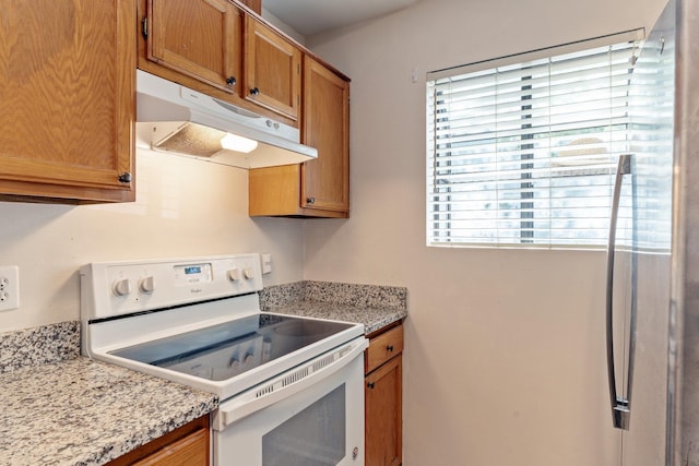 kitchen with light stone countertops and white electric range