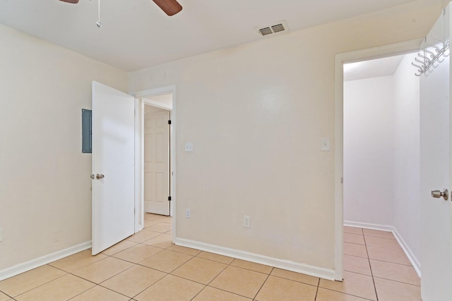 spare room with ceiling fan and light tile patterned floors