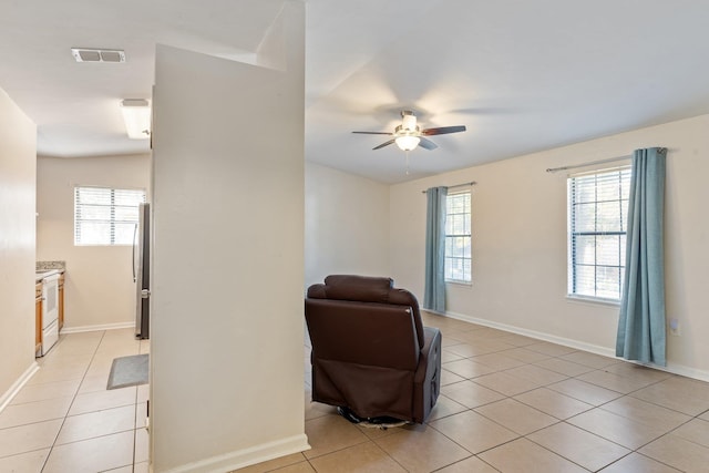 living area featuring ceiling fan and light tile patterned floors