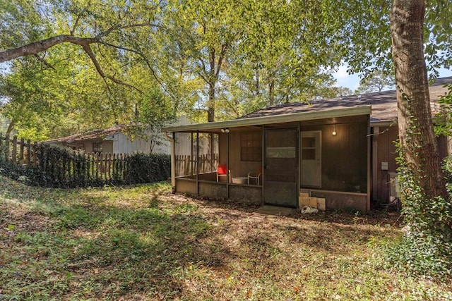 rear view of house featuring a sunroom