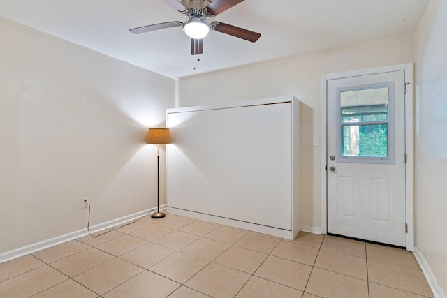 tiled foyer featuring ceiling fan