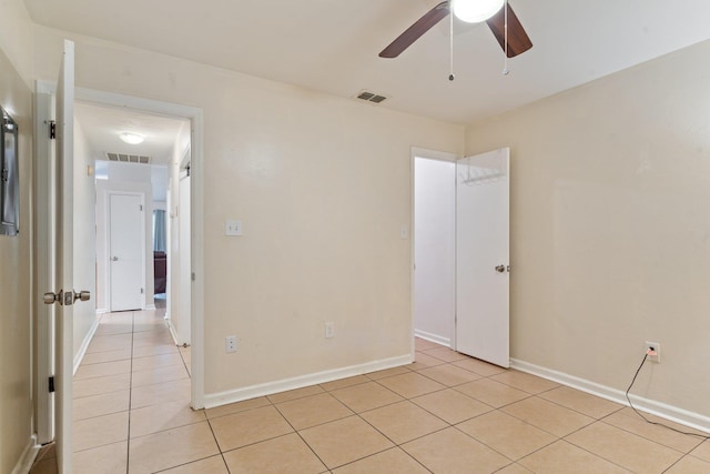 tiled spare room featuring ceiling fan