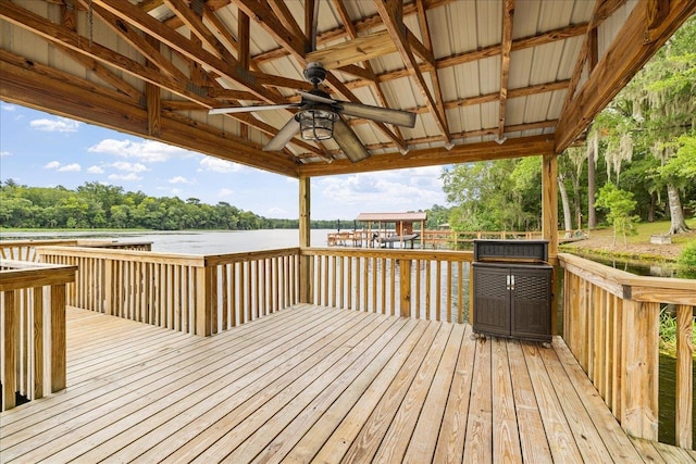 wooden terrace with a water view, ceiling fan, and a gazebo
