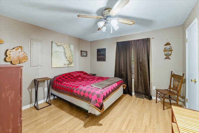 bedroom featuring hardwood / wood-style flooring, ceiling fan, and a textured ceiling