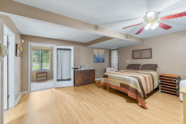 bedroom with a textured ceiling, light hardwood / wood-style floors, and ceiling fan