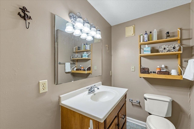bathroom with vanity, toilet, and a textured ceiling