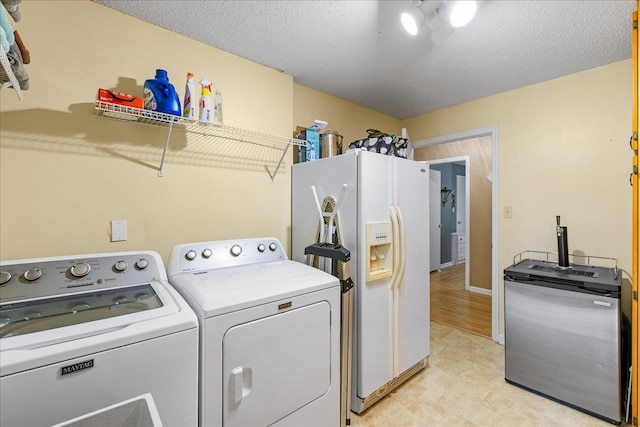 laundry area featuring washing machine and dryer and a textured ceiling