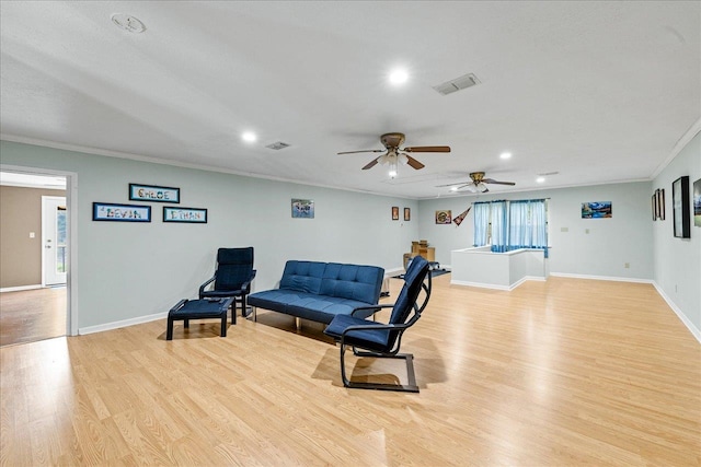 living area with ornamental molding, light wood-type flooring, and ceiling fan