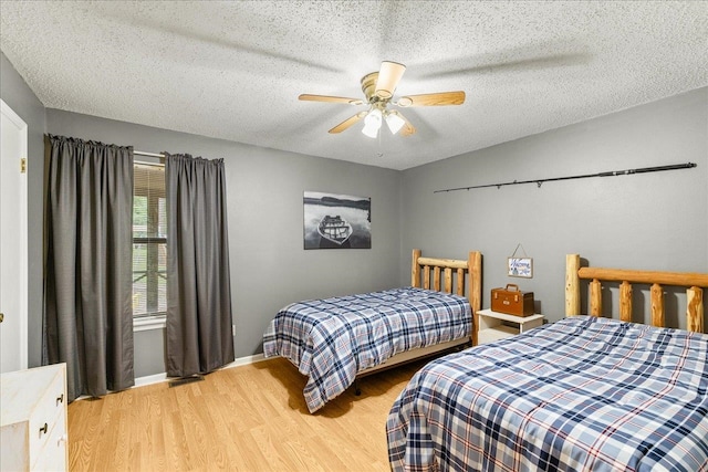 bedroom featuring a textured ceiling, light hardwood / wood-style flooring, and ceiling fan