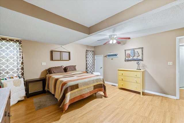 bedroom with light hardwood / wood-style floors, ceiling fan, and a textured ceiling