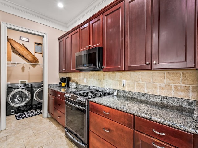 kitchen with appliances with stainless steel finishes, dark stone countertops, washer and clothes dryer, crown molding, and decorative backsplash