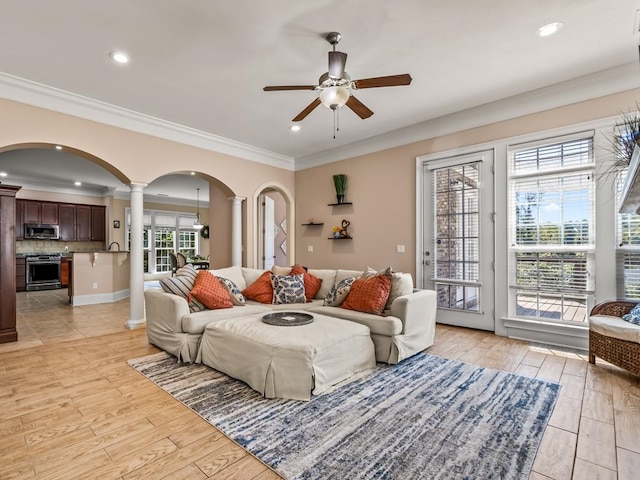 living room with crown molding, plenty of natural light, light hardwood / wood-style floors, and ceiling fan