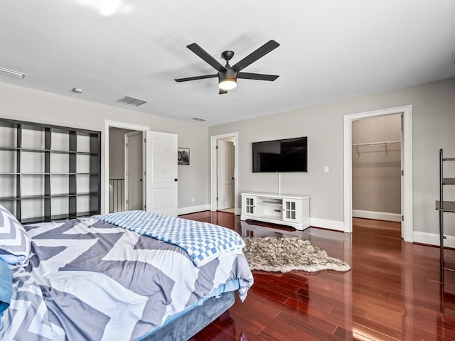 bedroom with a closet, a spacious closet, ceiling fan, and dark hardwood / wood-style floors