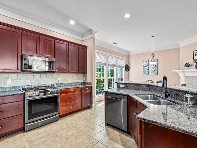 kitchen featuring crown molding, appliances with stainless steel finishes, pendant lighting, sink, and dark stone countertops