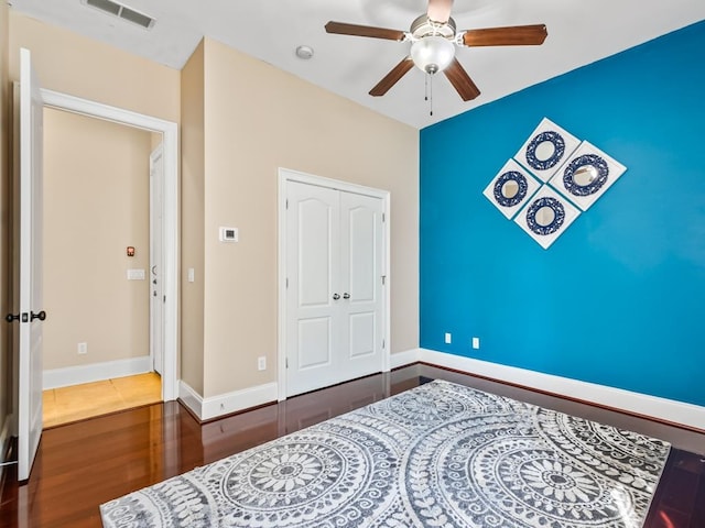 bedroom featuring dark hardwood / wood-style flooring, a closet, and ceiling fan