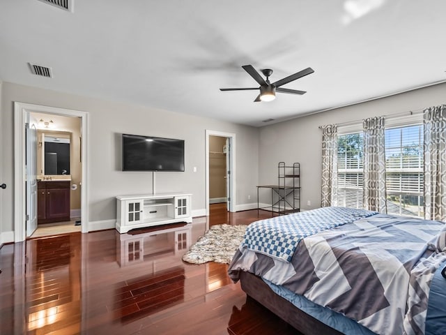 bedroom featuring a closet, a spacious closet, hardwood / wood-style floors, ceiling fan, and ensuite bathroom