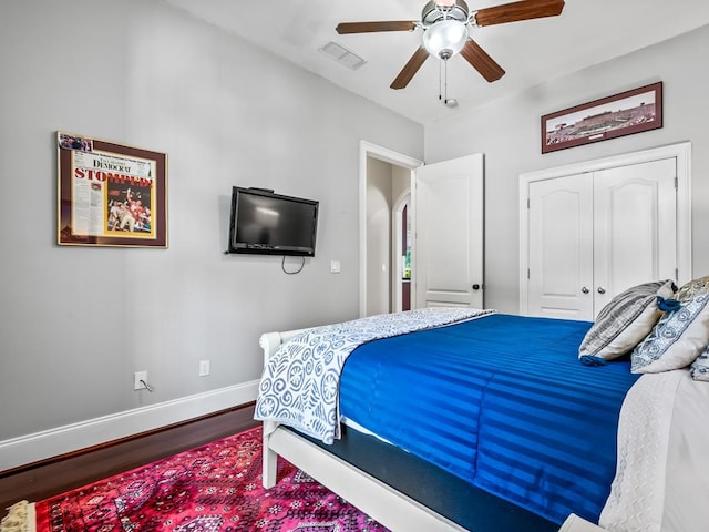 bedroom with a closet, hardwood / wood-style floors, and ceiling fan