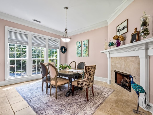 tiled dining space with a fireplace and crown molding