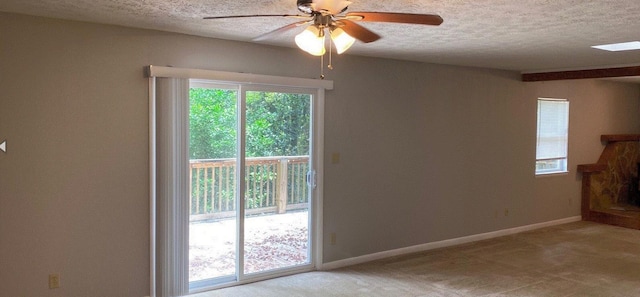 carpeted empty room with ceiling fan and a textured ceiling