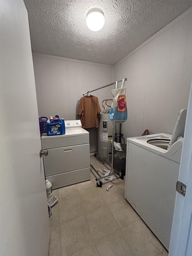 clothes washing area with washer and dryer, water heater, and a textured ceiling