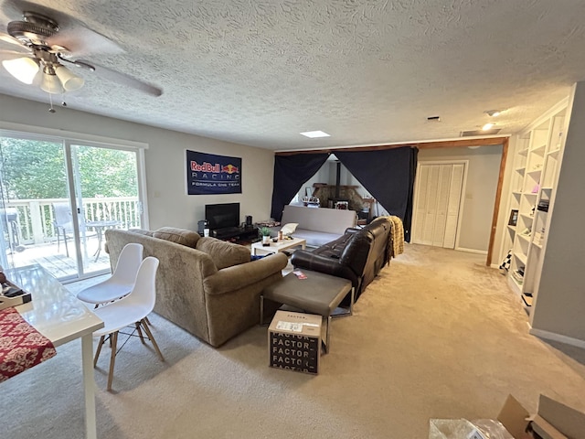 living room with a textured ceiling, light carpet, and ceiling fan