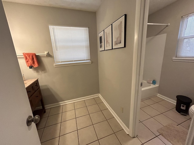 full bathroom featuring a textured ceiling, vanity, tile patterned flooring, and shower / washtub combination