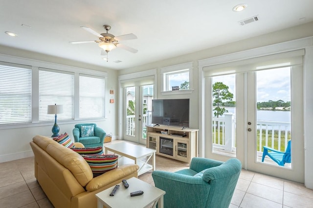 tiled living room with ceiling fan and a healthy amount of sunlight