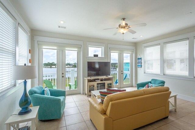 living room featuring plenty of natural light, light tile patterned floors, and ceiling fan