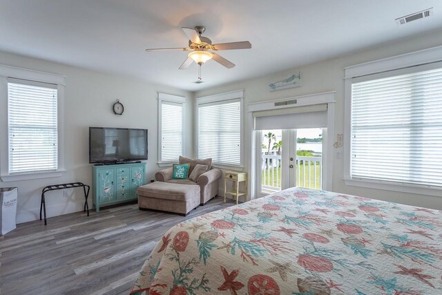 bedroom with ceiling fan, dark hardwood / wood-style floors, and access to exterior