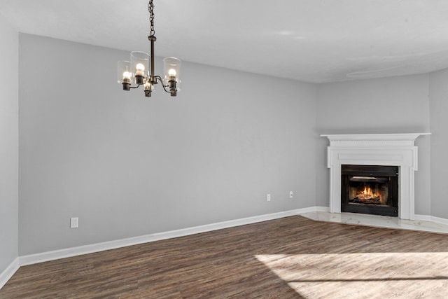 unfurnished living room featuring dark hardwood / wood-style flooring and a notable chandelier