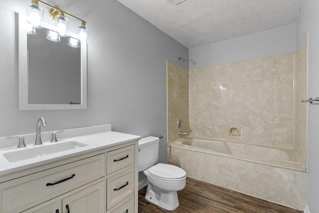 full bathroom featuring a textured ceiling, hardwood / wood-style flooring, toilet, shower / bath combination, and vanity