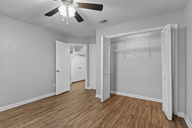 unfurnished bedroom featuring wood-type flooring, ceiling fan, and a closet