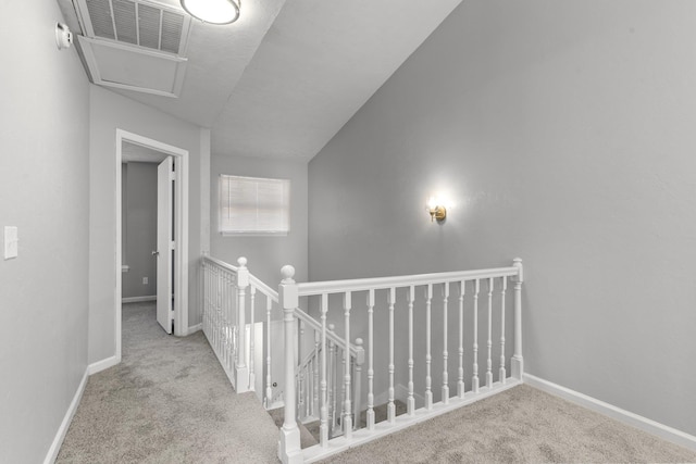 corridor with light carpet and vaulted ceiling