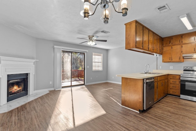 kitchen featuring kitchen peninsula, stainless steel appliances, dark hardwood / wood-style flooring, ceiling fan with notable chandelier, and sink