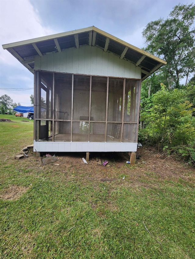 view of home's exterior with a sunroom and a yard