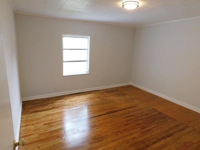 unfurnished room with hardwood / wood-style flooring and ornamental molding